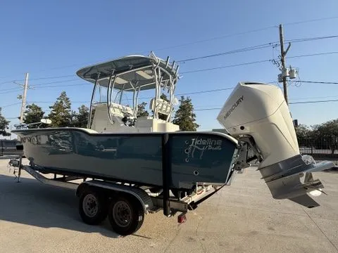 Slide: The Image of 2020 Tideline 235 Hybrid boat on trailer with outboard motor, parked outdoors. - 6