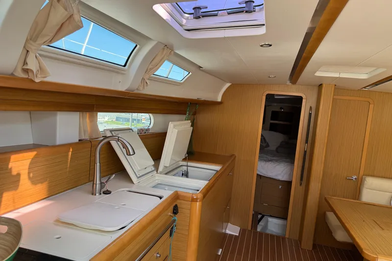 Slide: The Image of Interior of 2009 Jeanneau Sun Odyssey 44i yacht, featuring a modern kitchen and cozy cabin. - 21