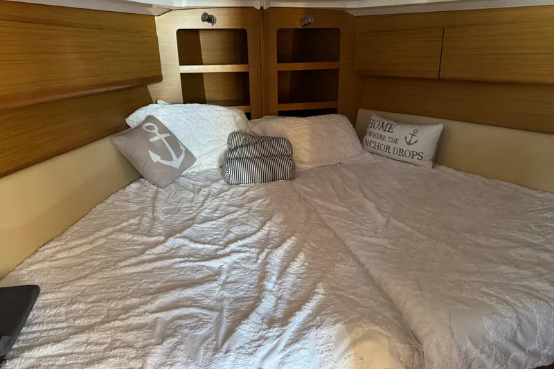 Slide: The Image of Cozy cabin interior of 2009 Jeanneau Sun Odyssey 44i with nautical-themed bedding. - 22