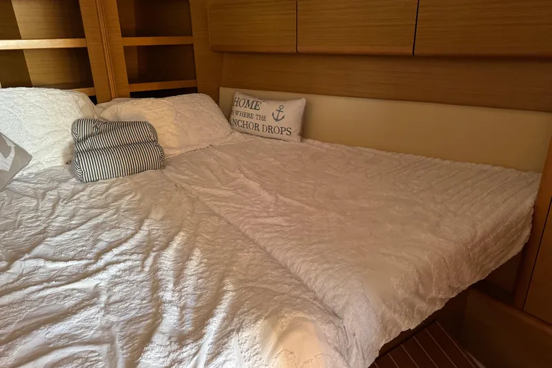 Slide: The Image of Cozy cabin interior of 2009 Jeanneau Sun Odyssey 44i with plush bedding and nautical decor. - 23