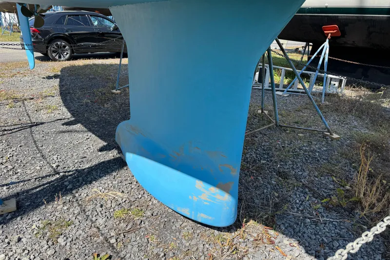 Slide: The Image of Keel of 2009 Jeanneau Sun Odyssey 44i sailboat on dry dock, with blue paint. - 6