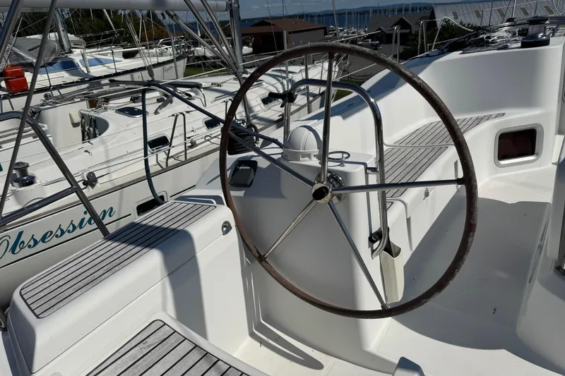 Slide: The Image of Steering wheel of a 2009 Jeanneau Sun Odyssey 44i sailboat in a marina. - 9
