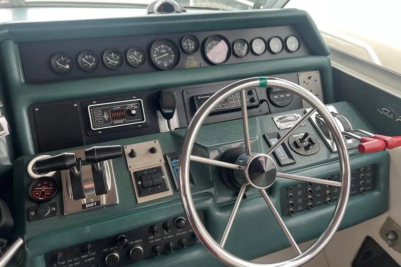 Slide: The Image of Control panel of a 1990 Sea Ray 350 Sundancer boat with steering wheel and gauges. - 10