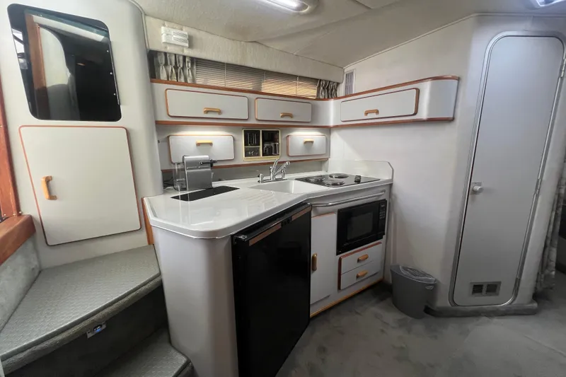 Slide: The Image of Interior of 1990 Sea Ray 350 Sundancer boat kitchen with modern appliances and cabinetry. - 15