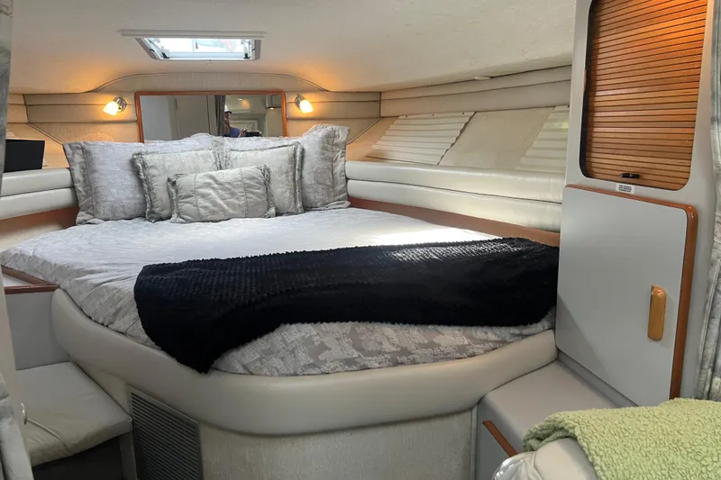Slide: The Image of Interior cabin of a 1990 Sea Ray 350 Sundancer with cozy bedding and ambient lighting. - 17