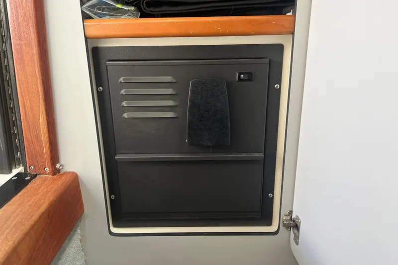 Slide: The Image of Black panel inside 1990 Sea Ray 350 Sundancer boat, surrounded by wood and white trim. - 21