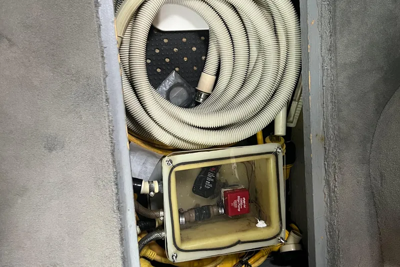 Slide: The Image of 1990 Sea Ray 350 Sundancer bilge area with hoses and electrical components. - 25