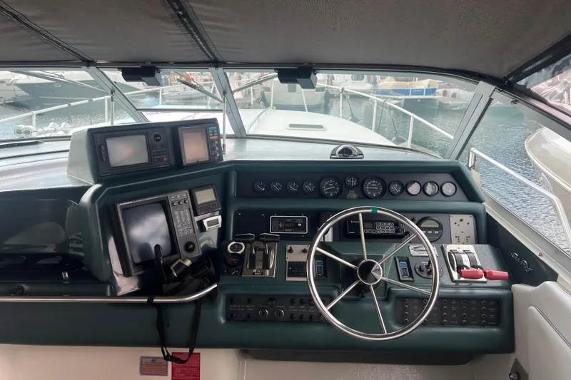 Slide: The Image of Cockpit of 1990 Sea Ray 350 Sundancer with navigation instruments and steering wheel. - 7