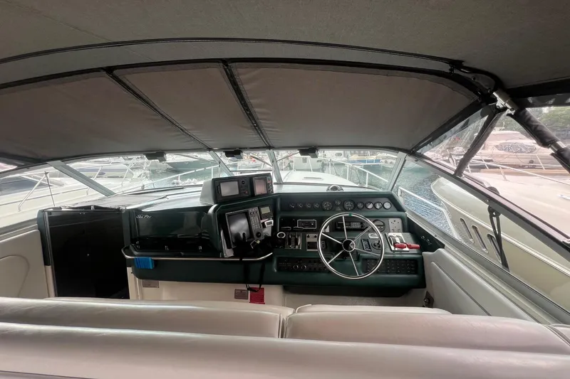 Slide: The Image of 1990 Sea Ray 350 Sundancer cockpit with steering wheel and navigation equipment. - 8