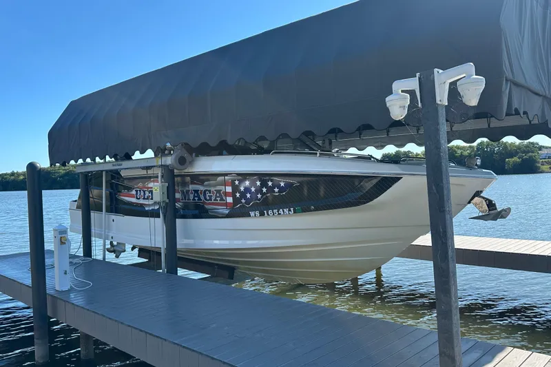 Slide: The Image of 2024 Galeon 320 GTO boat docked under a canopy on a sunny lake. - 4