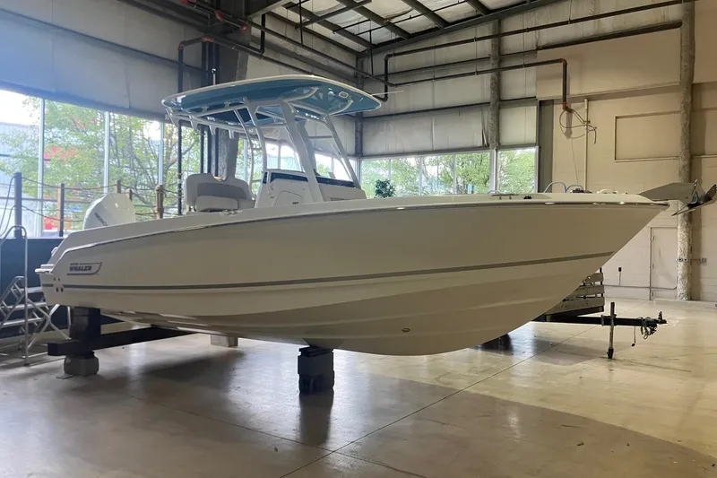 The Image of 2026 Boston Whaler 230 Outrage boat displayed in a spacious indoor showroom. - 0