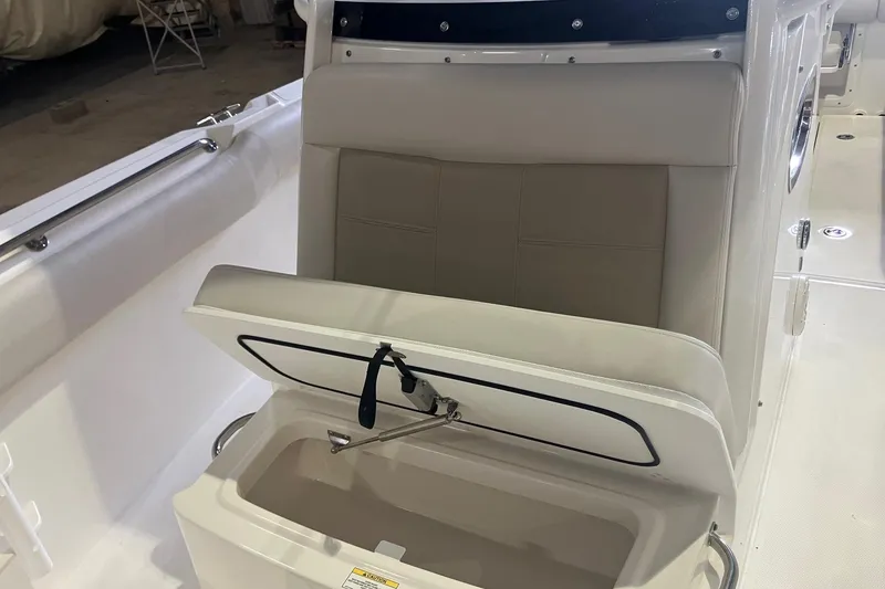 Slide: The Image of 2026 Boston Whaler 230 Outrage boat seat with open storage compartment. - 13