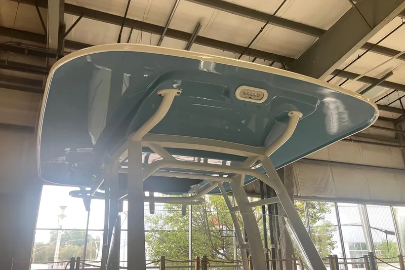 Slide: The Image of 2026 Boston Whaler 230 Outrage boat under a metal roof, showcasing its sleek design. - 4