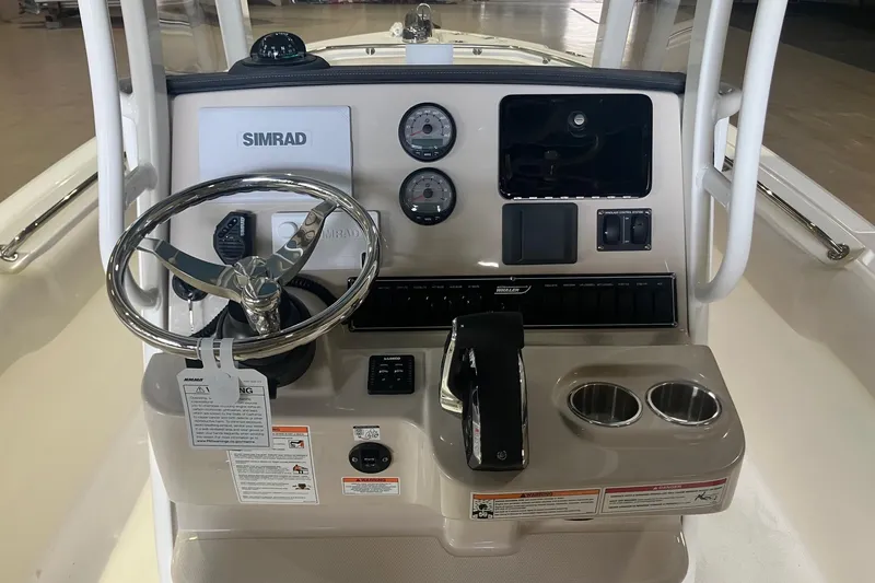 Slide: The Image of 2026 Boston Whaler 230 Outrage boat console with steering wheel and Simrad display. - 8