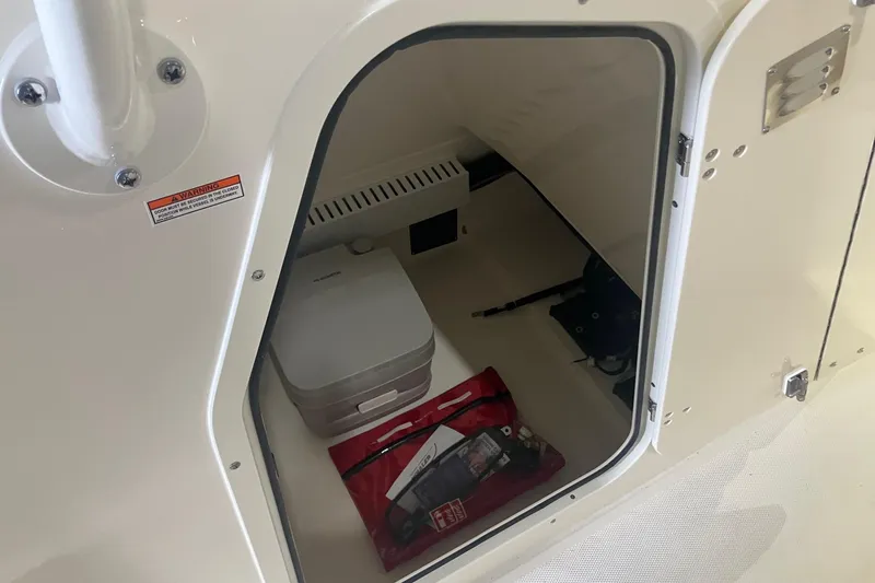 Slide: The Image of Storage compartment of 2026 Boston Whaler 230 Outrage boat, featuring safety equipment. - 9