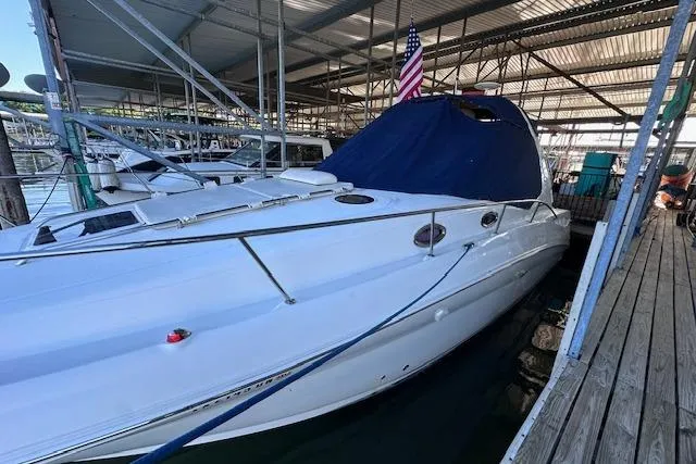 Slide: The Image of 2007 Sea Ray 320 Sundancer docked under a covered marina with an American flag. - 15