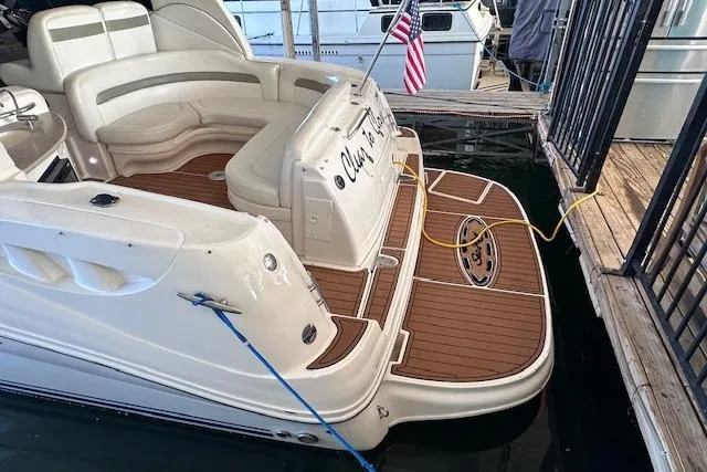 Slide: The Image of 2007 Sea Ray 320 Sundancer boat docked, featuring spacious seating and American flag. - 16