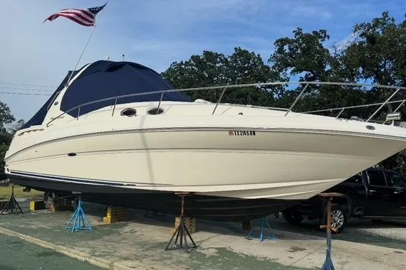 Slide: The Image of 2007 Sea Ray 320 Sundancer yacht on stands, American flag, outdoors, clear sky. - 2