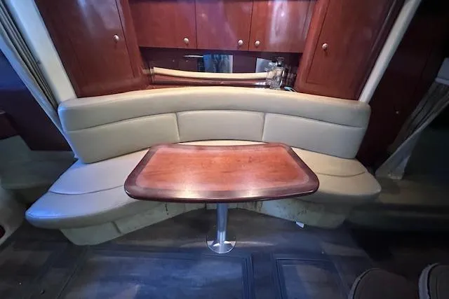 Slide: The Image of 2007 Sea Ray 320 Sundancer interior with curved seating and wooden table. - 26