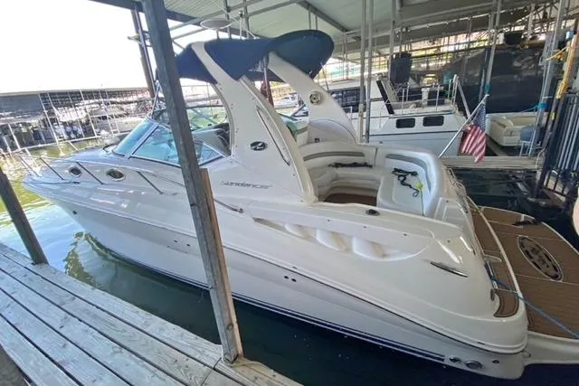 Slide: The Image of 2007 Sea Ray 320 Sundancer docked in a marina, featuring sleek design and spacious deck. - 3