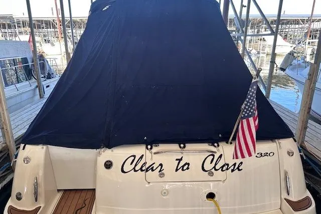 Slide: The Image of 2007 Sea Ray 320 Sundancer docked, covered, with American flag and "Clear to Close" text. - 36