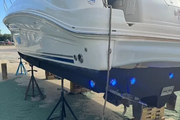 Slide: The Image of 2007 Sea Ray 320 Sundancer boat on stands with blue underwater lights. - 44