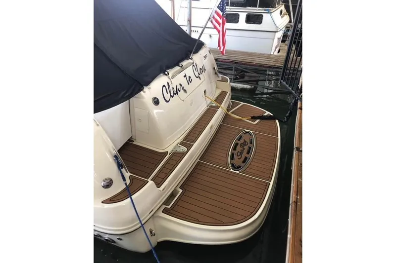 Slide: The Image of 2007 Sea Ray 320 Sundancer docked, featuring teak swim platform and American flag. - 5