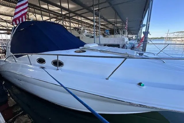Slide: The Image of 2007 Sea Ray 320 Sundancer docked under a covered marina with American flag. - 6