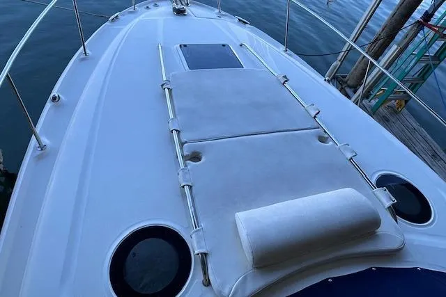 Slide: The Image of 2007 Sea Ray 320 Sundancer boat deck with sunpad and railing, docked by the water. - 8