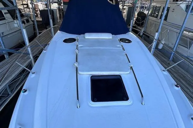 Slide: The Image of 2007 Sea Ray 320 Sundancer boat deck with sunpad and hatch, docked in marina. - 9