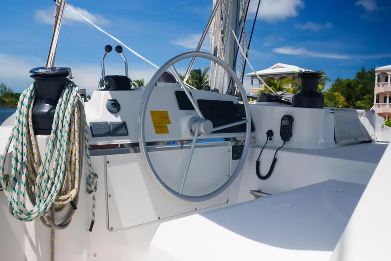 Slide: The Image of Steering wheel of 2023 Bali 4.4 yacht with ropes and controls, under clear blue sky. - 10