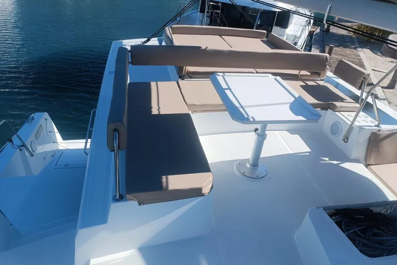 Slide: The Image of Luxurious 2023 Bali 4.4 yacht deck with seating and table, docked by the water. - 13