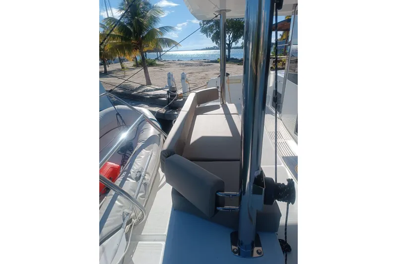 Slide: The Image of 2023 Bali 4.4 yacht deck with seating, palm trees, and ocean view. - 53