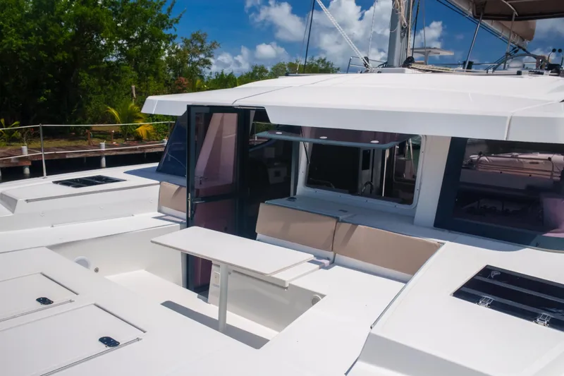 Slide: The Image of 2023 Bali 4.4 yacht deck with seating and table, surrounded by lush greenery. - 57