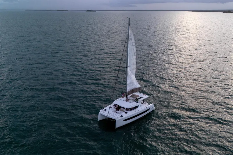Slide: The Image of Sailing catamaran Bali 4.4, 2023 model, cruising on open sea at sunset. - 60