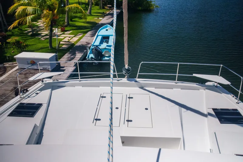 Slide: The Image of Front deck of 2023 Bali 4.4 yacht docked by a serene waterfront. - 8
