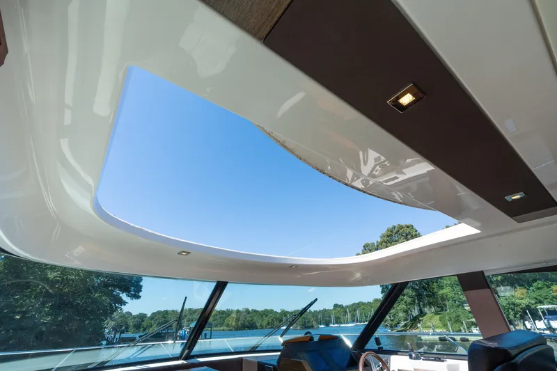 Slide: The Image of Interior view of 2015 Tiara Yachts C44 Coupe with open sunroof and scenic background. - 18