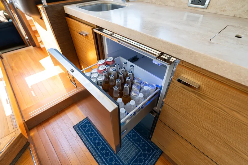 Slide: The Image of Open drawer fridge in 2015 Tiara Yachts C44 Coupe galley, stocked with beverages. - 23