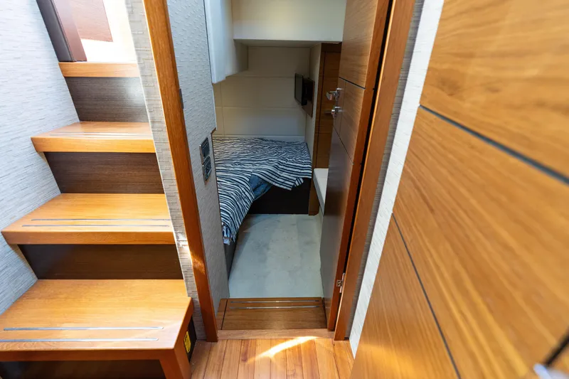 Slide: The Image of Interior of 2015 Tiara Yachts C44 Coupe, featuring wooden stairs and cozy cabin. - 30
