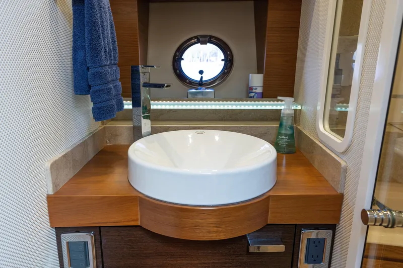 Slide: The Image of Luxurious bathroom sink in 2015 Tiara Yachts C44 Coupe with modern fixtures and porthole window. - 35