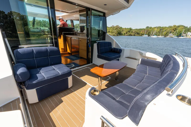 Slide: The Image of 2015 Tiara Yachts C44 Coupe with luxurious seating on deck, overlooking serene waters. - 37