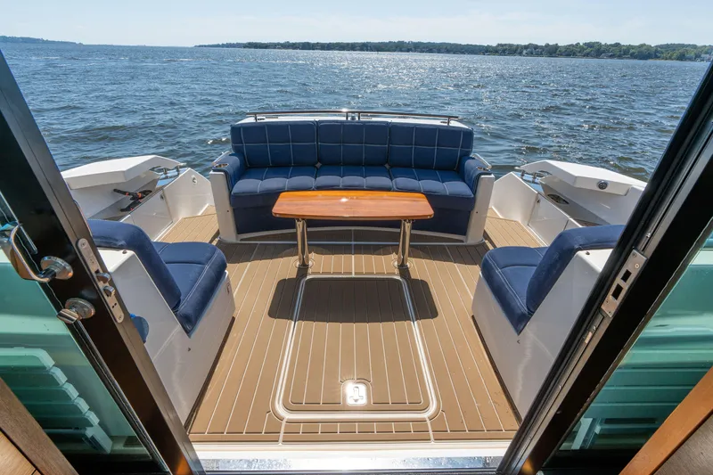 Slide: The Image of Luxurious 2015 Tiara Yachts C44 Coupe deck with seating and table, overlooking serene waters. - 41