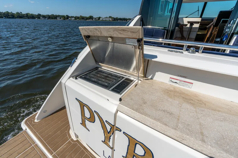 Slide: The Image of Outdoor grill on 2015 Tiara Yachts C44 Coupe, docked by a scenic waterfront. - 49