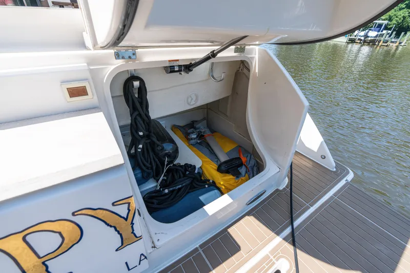 Slide: The Image of Open storage compartment on 2015 Tiara Yachts C44 Coupe, docked by the water. - 51