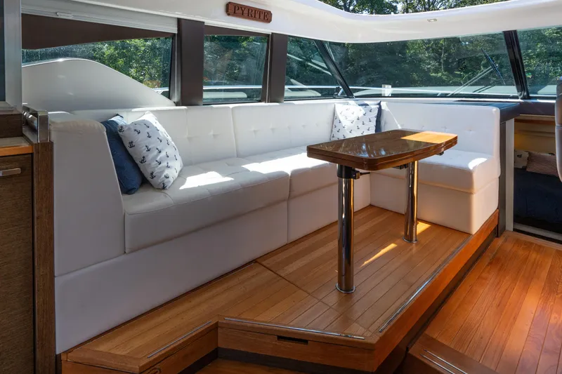 Slide: The Image of Luxurious interior of 2015 Tiara Yachts C44 Coupe with white seating and wooden table. - 7