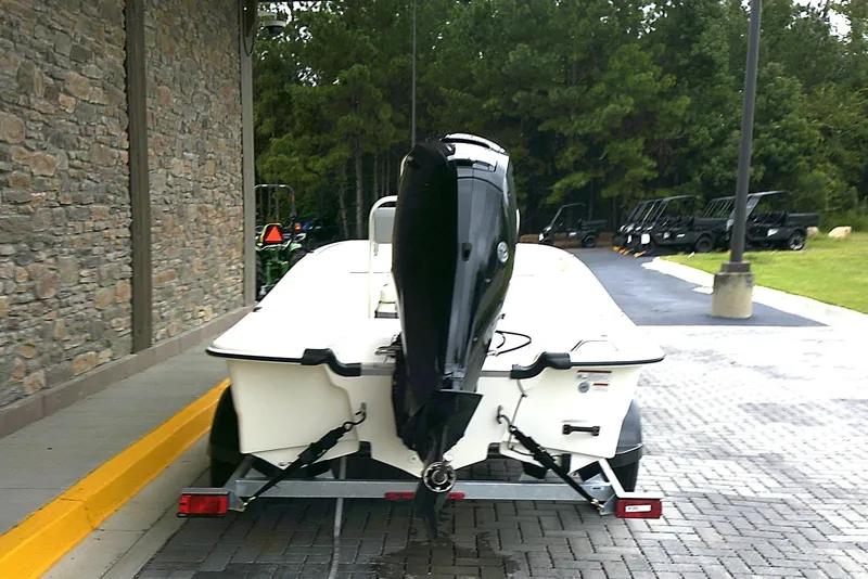 Slide: The Image of 2026 Mako Pro Skiff 17 CC on trailer, parked outdoors near stone wall. - 3