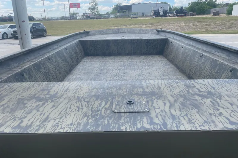 Slide: The Image of 2026 Tracker Grizzly 1860 Utility boat interior with camouflage pattern, parked outdoors. - 6