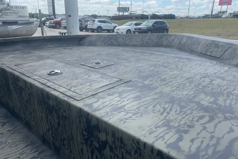 Slide: The Image of 2026 Tracker Grizzly 1860 Utility boat with camouflage pattern, parked outdoors. - 7