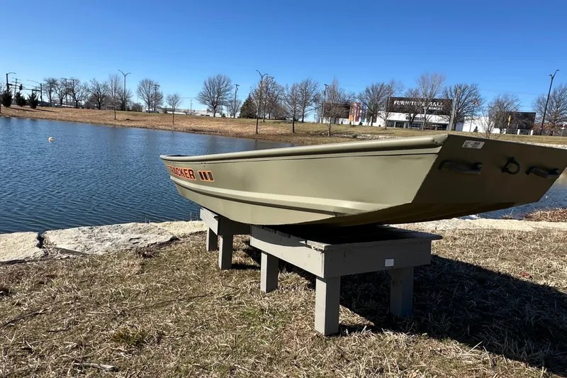 Slide: The Image of 2026 Tracker Grizzly 10 Jon boat displayed by a serene lake under clear blue skies. - 4