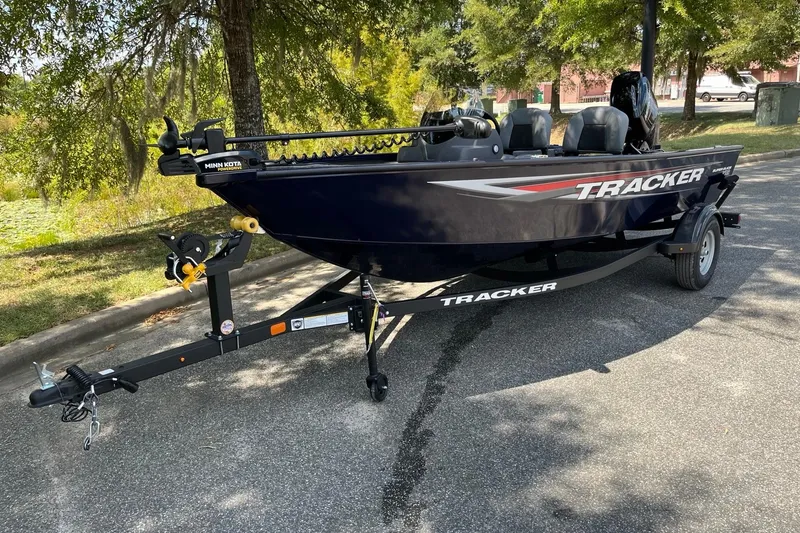 The Image of 2026 Tracker Super Guide V-16 SC boat on trailer, parked outdoors. - 1
